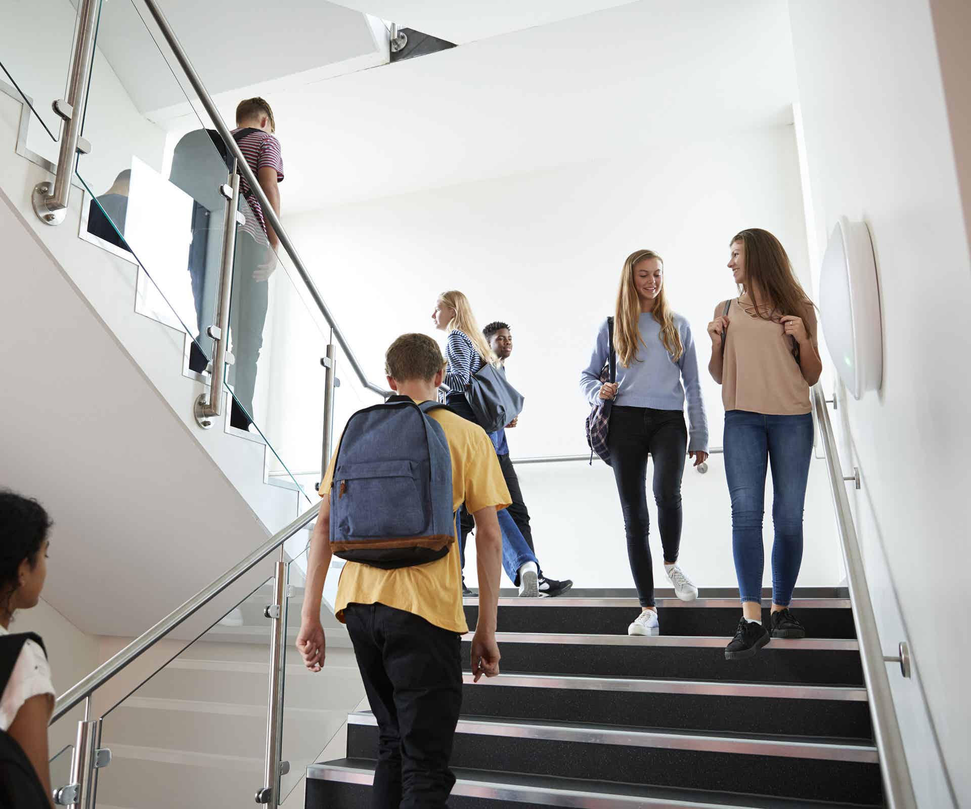 High school students walk on a stairwell in an education facility 